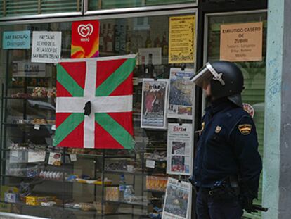 Un policía custodia la tienda donde ocurrió el tiroteo ayer en Pamplona.