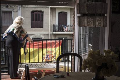 Una vecina coloca en su balc&oacute;n una bandera espa&ntilde;ola, frente a una casa con la estelada nacionalista catalana, en una calle de Barcelona.
 
 
 