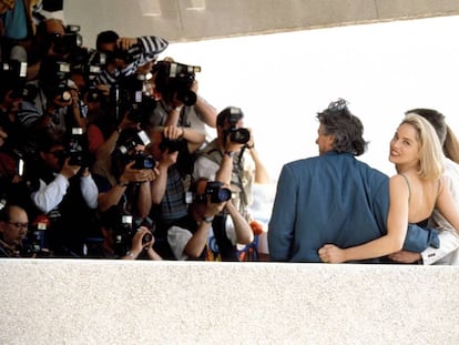 No Festival do Cannes de 1992, Sharon Stone, prestes a se tornar uma estrela mundial, dedica um sorriso a um fotógrafo enquanto seus colegas da equipe em ‘Instinto Selvagem’ posam para outros.