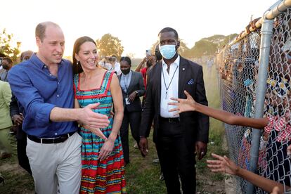 Los duques de Cambridge saludan a niños en Trench Town, Kingston, Jamaica, a través de una valla, en su viaje por el Caribe, en marzo de 2022.