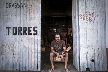 Miquel Torres, sentado en la puerta de su astillero particular, donde ahora construye guitarras. 