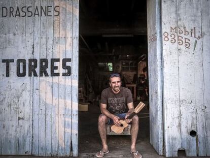Miquel Torres, sentado en la puerta de su astillero particular, donde ahora construye guitarras. 