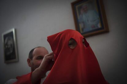 Un penitante de la hermandad de Jesús Flagelado se prepara antes de la procesión, en Santiago de Compostela.