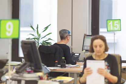 Varias personas trabajan en una oficina pública de empleo.