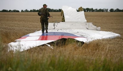 A linha aérea Malaysia Airlines informou na rede social Twitter da perda de contato com o voo MH017. Na fotografia, um soldado caminha sobre os restos do avião.