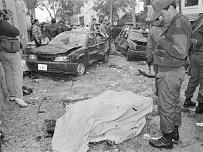 Un policía observa un cadáver tras un atentado de Sendero Luminoso en Lima en 1995.