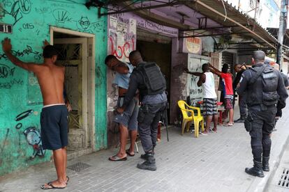 Moradores da Rocinha são revistados pela Polícia que, apesar das ações, não consegue frear a escalada de violência entre os grupos rivais de traficantes