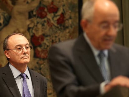 El gobernador del Banco de España, Luis María Linde, escucha a su antecesor, Miguel Ángel Fernández Ordóñez.