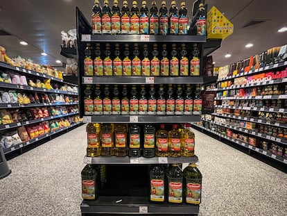 Expositor de botellas de aceite de oliva en un supermercado.