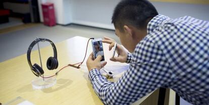 Un cliente manipula un móvil de Xiaomi en una tienda de Pekín.