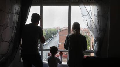 Miguel, Dara e seu filho olham pela janela do apartamento que ocupam.