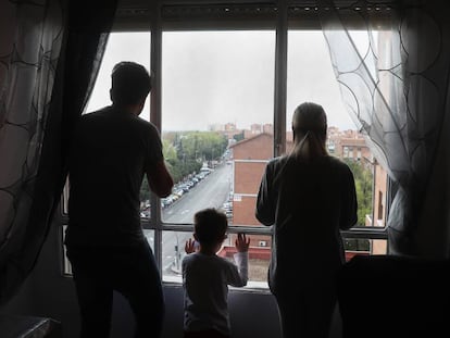 Miguel, Dara e seu filho olham pela janela do apartamento que ocupam.