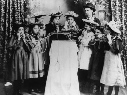 Un grupo de personas prueba una primitiva gramola en Salina, Kansas (c. 1895)