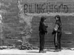 Dos adolescentes conversan junto a una de las pintadas a favor del bilingüismo que aparecieron  en Barcelona en 1997.