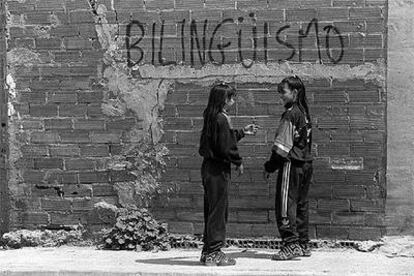 Dos adolescentes conversan junto a una de las pintadas a favor del bilingüismo que aparecieron  en Barcelona en 1997.