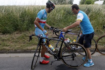 El ciclista italiano Vincenzo Nibali (izq), del equipo Astana, cambia de bicicleta antes de enfrentarse a una zona adoquinada.