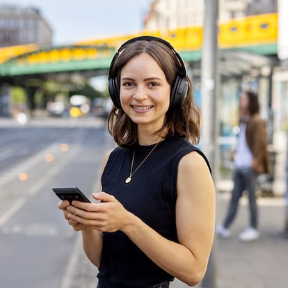 Una mujer en la calle con sus auriculares.
