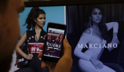 Una persona observa la página web de la tienda Guess.
