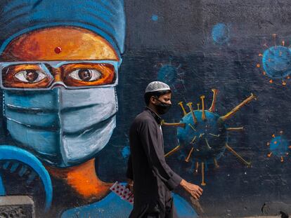 Un hombre camina ante un mural dedicado al coronavirus, el jueves en Bombay.