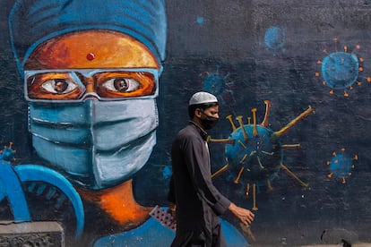 Un hombre camina ante un mural dedicado al coronavirus, el jueves en Bombay.