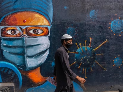 Un hombre camina ante un mural dedicado al coronavirus, el jueves en Bombay.