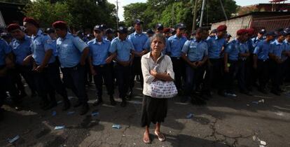 Una anciana protesta frente a un grupo de policías.