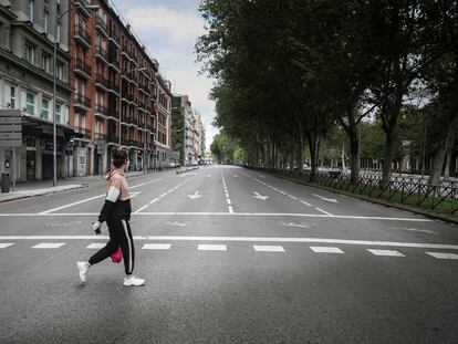 Una mujer cruzando un vacío Paseo del Prado de Madrid, durante el estado de alarma.