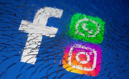 Los logos de Facebook, Whatsapp e Instagram, vistos a través de un cristal roto.