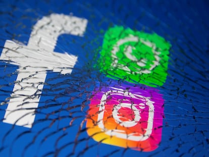 Los logos de Facebook, Whatsapp e Instagram, vistos a través de un cristal roto.