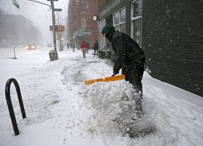 Un empleado retira la nieve de un establecimiento en la ciudad de Nueva York (EE UU).