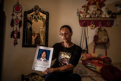 Claudia Londoño sostiene el retrato de su hija, Melanie, en su habitación, en La Plata, Colombia.