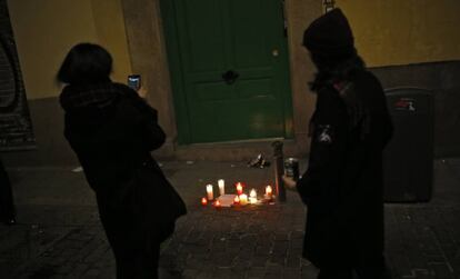 Dos mujeres junto a un altar improvisado en el lugar donde falleció un mantero en el madrileño barrio de Lavapiés.