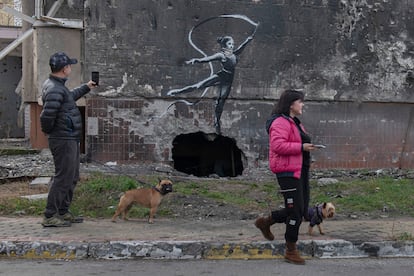 Dos ciudadanos pasan por delante de otra de las obras atribuidas a Banksy.