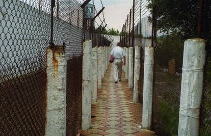 El director médico de la Colonia 3, Nikolai Gopilo, anda por uno de los patios donde están los prisioneros tuberculosis resistente a los medicamentos. El recinto parace un pequeño pueblo donde los residentes pueden andar libremente sin restricciones. Está asegurado por vallas dobles, torres y patrullas con guardias armados y un sistema de restricción de entrada. Algunos de los reclusos, además padecen VIH y son adictos.