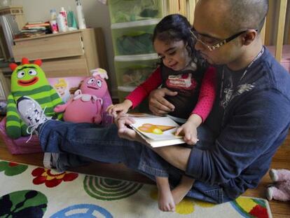 Christopher Astacio lee con su hija, Cristina de dos años, diagnosticada de autismo.