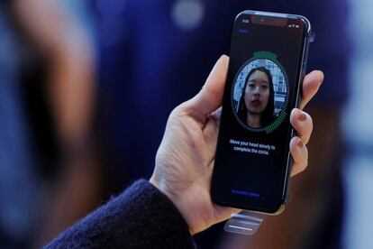 FILE PHOTO: A woman sets up her facial recognition as she looks at her Apple iPhone X at an Apple store in New York, U.S., November 3, 2017. REUTERS/Lucas Jackson/File Photo