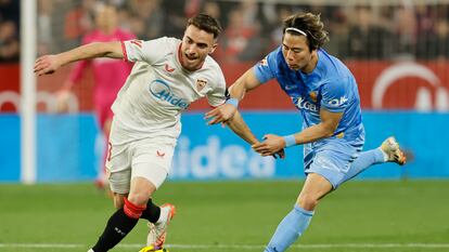 El defensa del Sevilla Adrià Pedrosa disputa un balón con el delantero del Mallorca Takuma Asano.