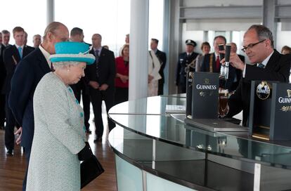 La reina Isabel II espera, junta al príncipe Felipe, duque de Edimburgo, que le sirvan una pinta en la sede de Guinness en Dublín.