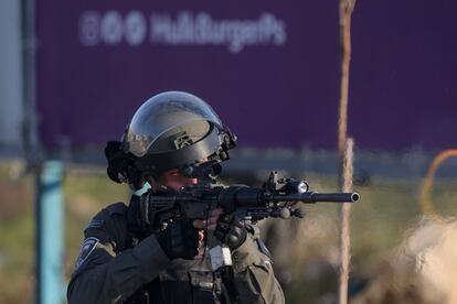 Un soldado israelí apunta con su rifle al grupo de manifestantes palestinos situados en la entrada norte de la ciudad de Remallah, cerca de el asentamiento judio de Beit.