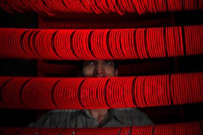 Un trabajador colorea brazaletes en un taller, antes de la fiesta musulmana Eid Al Adha, en Lahore (Pakistán).
