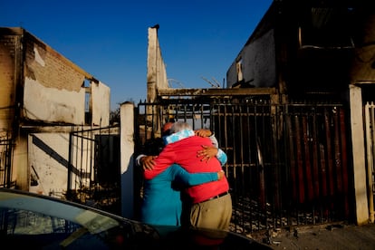 Pobladores se abrazan después de que un incendio forestal llegara a su vecindario en Viña del Mar.