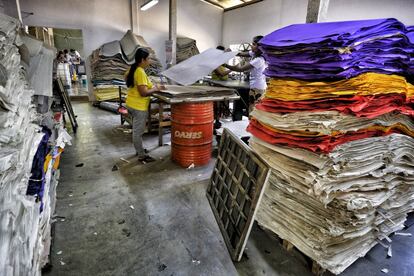 Una empleada supervisa la calidad del papel antes de pasar al proceso de manufacturación del producto final.