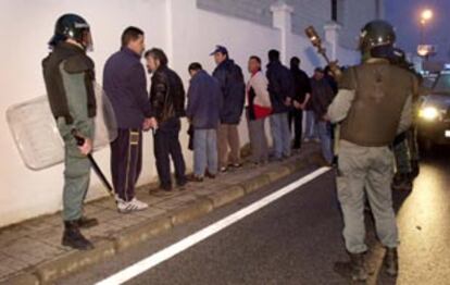 Tres guardias civiles retienen a un grupo de huelguistas, durante los incidentes de la madrugada pasada.