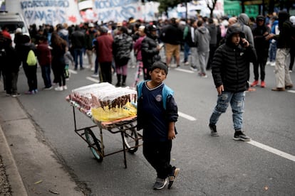 El joven David Azurduy vende dulces a la gente que marcha en el Día Internacional de los Trabajadores en Buenos Aires.