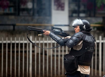 A police officer fires a rubber bullet at protesters on May 8, 2014 in Caracas.