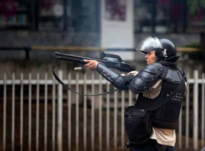 A police officer fires a rubber bullet at protesters on May 8, 2014 in Caracas.