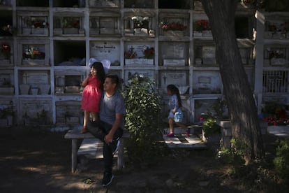 Uma família visita o túmulo de um parente no cemitério de Santiago (Chile), em 1 de novembro de 2016.