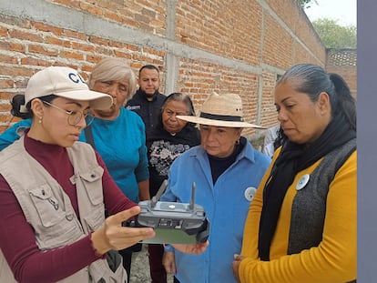 Un miembro de la Comisión de Búsqueda de Jalisco enseña a madres buscadoras a usar el control remoto de un dron en Cajititlán, Jalisco, en diciembre de 2023.