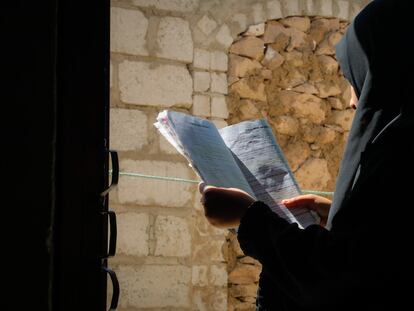 Asma'a, una niña de 15 años que se libró del matrimonio infantil, lee un libro desde el patio de su casa en Dhamar, Yemen.