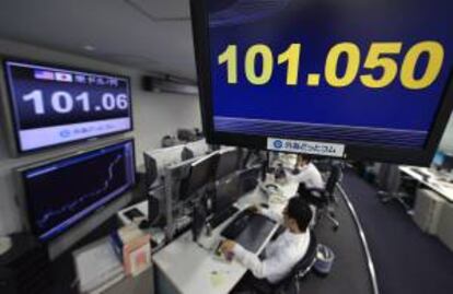 Varios monitores muestran el cambio del yen al dólar en una oficina de corretaje en Tokio.
